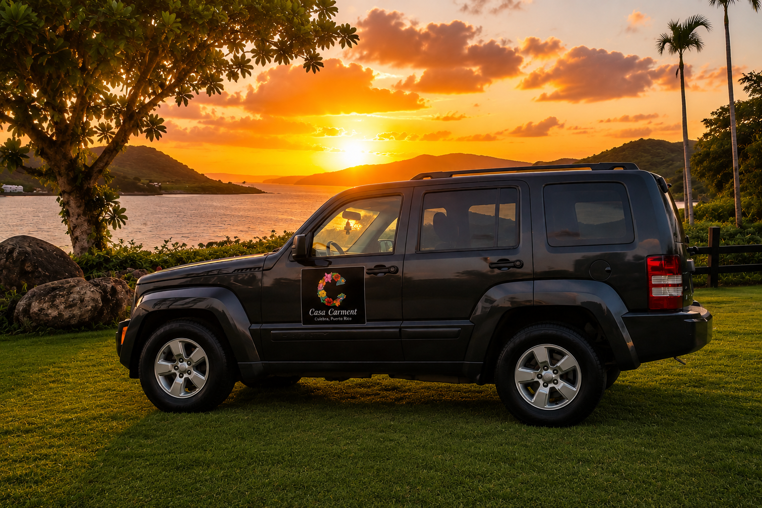 Dark grey 2011 Jeep Liberty with the Casa Carmen logo parked on grass above the bay at sunset in Culebra