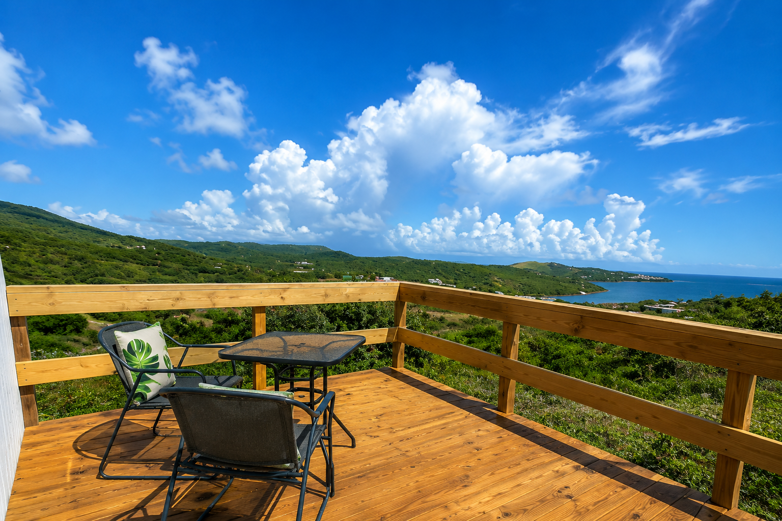 Private terrace with seating and panoramic views over the bay and green hills