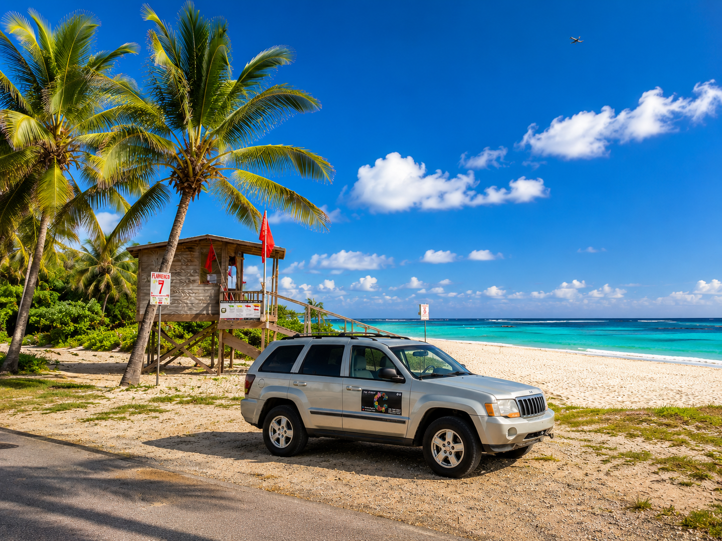 Silver 2007 Jeep Grand Cherokee with the Casa Carmen logo parked beside the lifeguard tower at Flamenco Beach