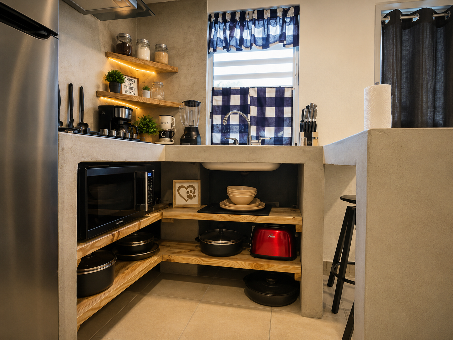 Close-up of the Rota kitchen with concrete counters, open wood shelving, microwave, coffee maker and blender