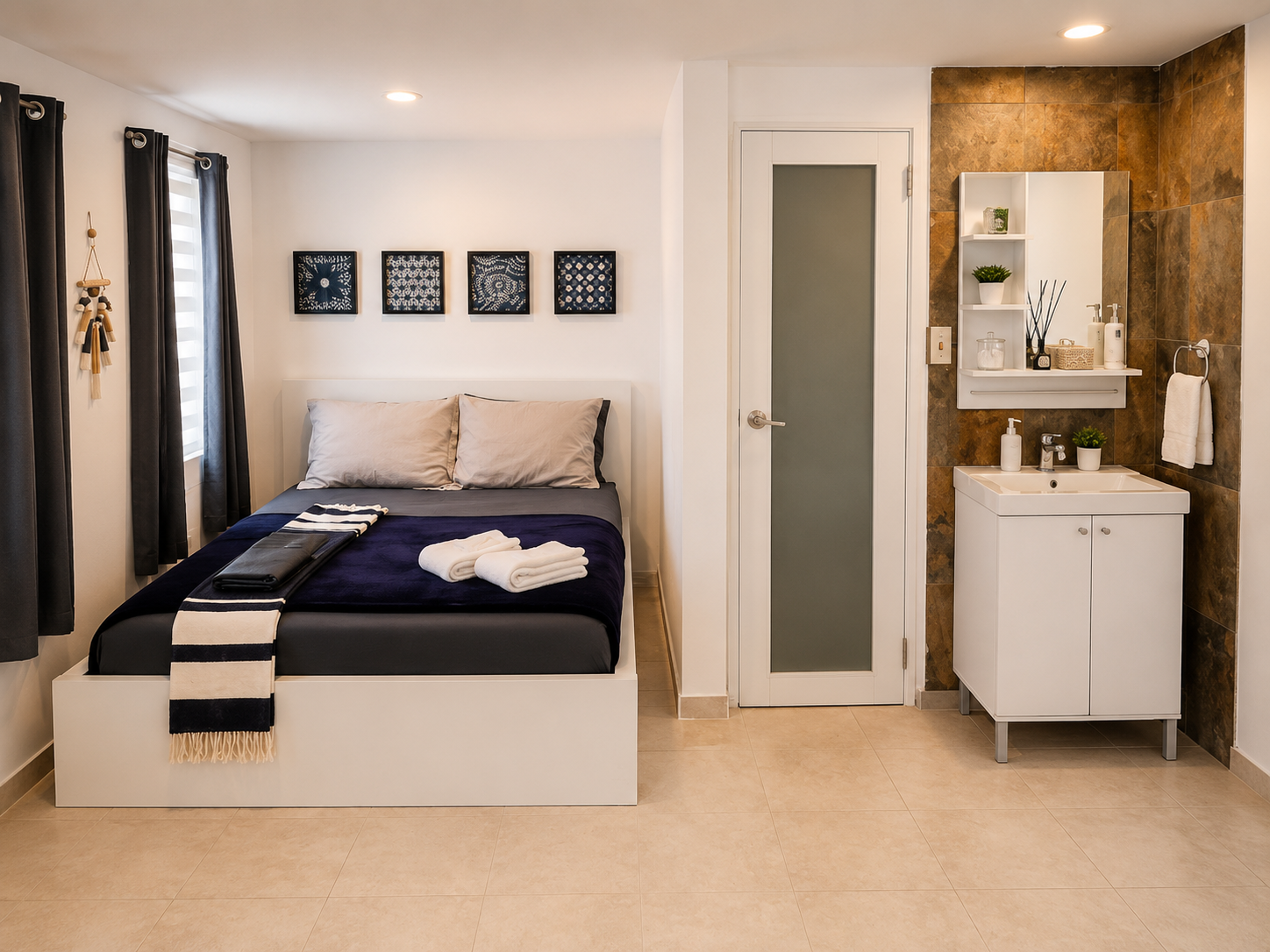 Rota bedroom with a queen bed, framed artwork, vanity sink and bathroom entrance